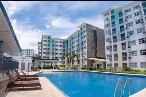 a swimming pool in front of a large building at Davao City Condo Living Made Easy Lifestyle in Davao City