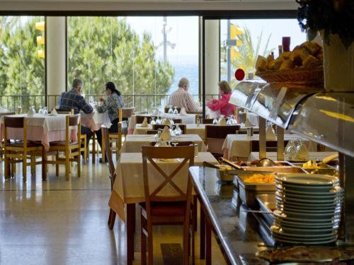 a restaurant with people sitting at tables in a restaurant at Hotel Parc in Roses