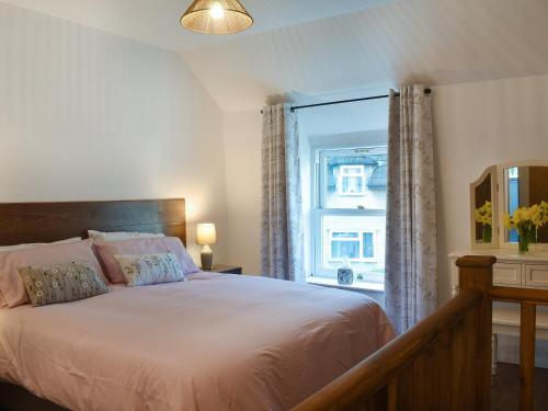 a bedroom with a large bed and a window at Nant Y Felin in Llanfairfechan