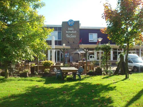 a building with a picnic table in the grass at Hotel and Restaurant van Saaze in Kraggenburg