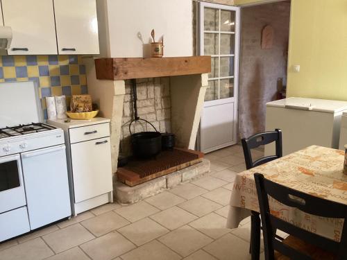 Il comprend une cuisine équipée d'une cuisinière et d'une cheminée. dans l'établissement Maison 4 pers proche chatelaillon plage, à Ballon