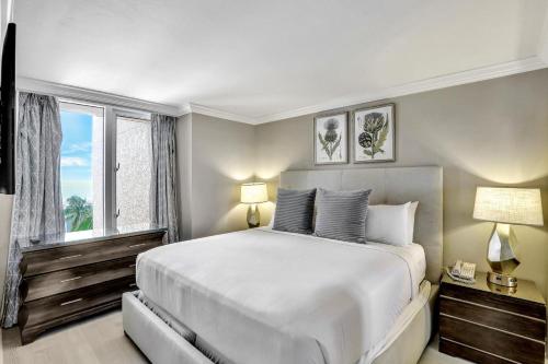 una camera da letto con un grande letto bianco e una finestra di Marco Beach Ocean Resort Unit 905 a Marco Island