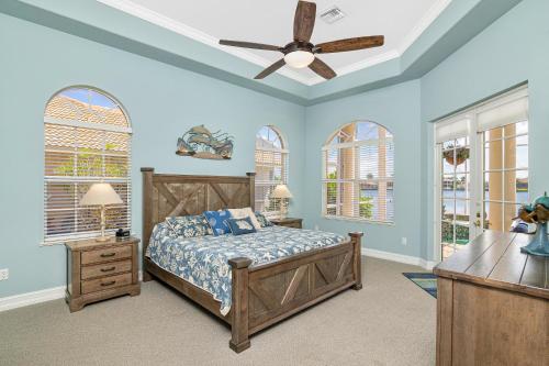 a bedroom with a bed and a ceiling fan at Waterfront home with pool, spa and 2nd floor balcony in Marco Island
