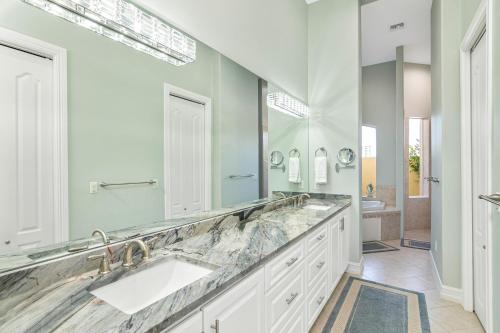 a bathroom with two sinks and a large mirror at Waterfront home with pool, spa and 2nd floor balcony in Marco Island