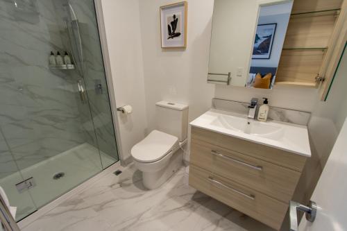 uma casa de banho com um chuveiro, um WC e um lavatório. em Luxurious inner city 2 bed pad em Christchurch