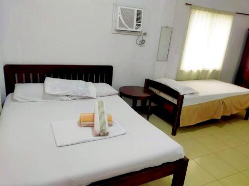 a hotel room with two beds and a table with a tray at OYO 931 Moreno's Place in Boracay