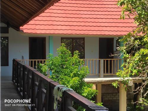 a house with a balcony and a red roof at LilyPad guest house in Kuta Lombok