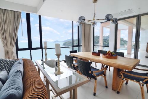 a living room with a couch and a table with chairs at Bandara Pool Villas, Phuket in Panwa Beach