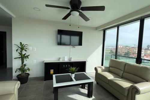 a living room with a couch and a ceiling fan at Luxury 2BR Condo Rosarito (G) in Rosarito