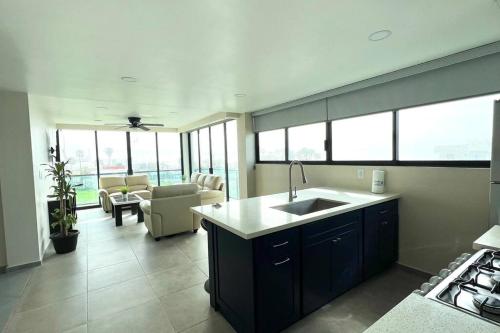 a kitchen with a sink and a living room at Luxury 2BR Condo Rosarito (G) in Rosarito
