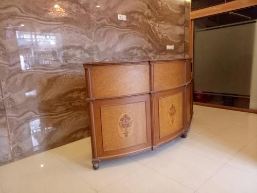 a wooden cabinet in front of a stone wall at Damai Guest House Cirebon in Cirebon