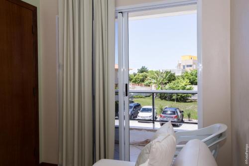 une chambre avec un balcon avec vue sur une voiture dans l'établissement Apartamentos Praia Campeche 50m do mar, à Florianópolis