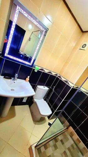 a bathroom with a sink and a toilet and a mirror at Résidence Costa Cabo in Martil