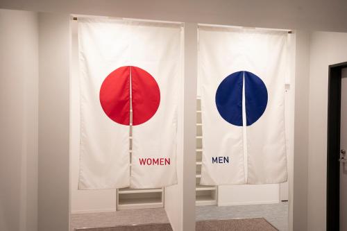 duas bandeiras numa parede com as palavras mulheres e homens em WeBase Kyoto em Quioto