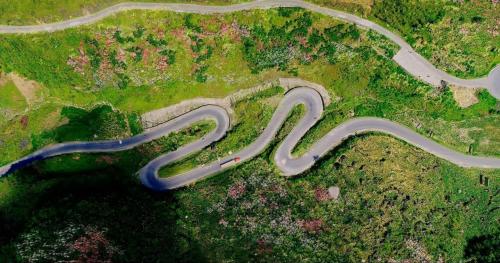 an aerial view of a winding road in the grass at Sun Hà Giang Hotel-tours-motorbike rental in Ha Giang