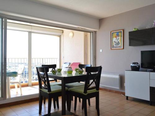 une salle à manger avec une table, des chaises et une télévision dans l'établissement Appartement 4 pers avec terrasse et parking, plage à 150 m - Cap d'Agde - FR-1-249-27, au Cap d'Agde