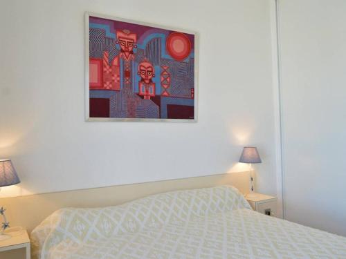 une chambre avec un lit et un tableau au mur dans l'établissement Appartement 4 pers avec terrasse et parking, plage à 150 m - Cap d'Agde - FR-1-249-27, au Cap d'Agde