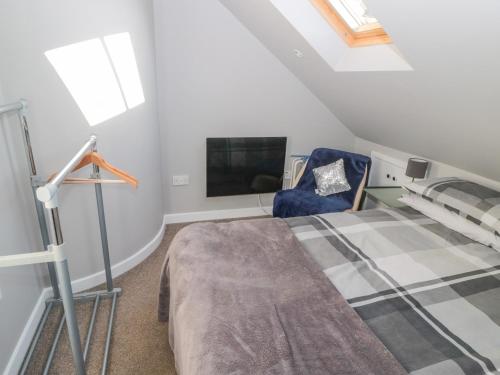 a attic bedroom with a bed and a tv at The Apartment in Longframlington