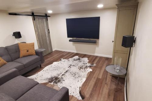 a living room with a couch and a flat screen tv at Luxury DT Cottage - Free Parking - Self Check-In in Anchorage