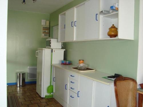 une cuisine avec des armoires blanches et un réfrigérateur blanc dans l'établissement Maison 3 pièces avec jardin, proche centre et plages, Saint-Denis-d'Oléron - FR-1-246A-339, à Saint-Denis-dʼOléron