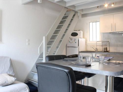 une cuisine avec une table et des chaises ainsi qu'un escalier dans l'établissement Maison à 400m de la plage, terrasse privée, 4 couchages, tout confort - Dolus d'Oléron - FR-1-246A-330, à Dolus-d'Oléron