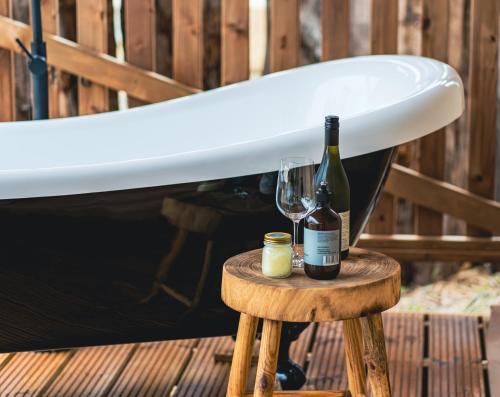 a surfboard and two bottles of wine on a table at Glamping 148 Tasmania in St Helens