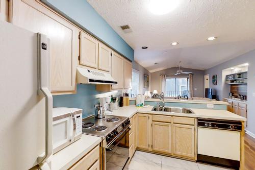 a kitchen with wooden cabinets and a white refrigerator at Pinehurst X-7 in Little River