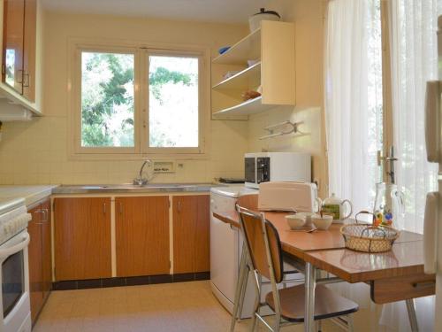 une petite cuisine avec une table et un évier dans l'établissement Villa californienne 4 chambres, terrasse vue mer, parking, animaux admis - FR-1-251-310, au Lavandou
