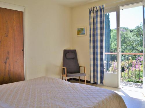une chambre avec un lit, une chaise et une fenêtre dans l'établissement Villa californienne 4 chambres, terrasse vue mer, parking, animaux admis - FR-1-251-310, au Lavandou