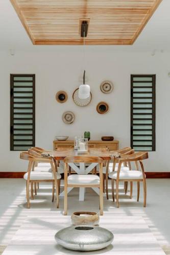 a dining room with a wooden table and chairs at Peninsula Beach Villa with LOV in Cap Malheureux