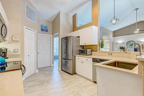 a kitchen with white cabinets and a stainless steel refrigerator at R-Time in Sebastian
