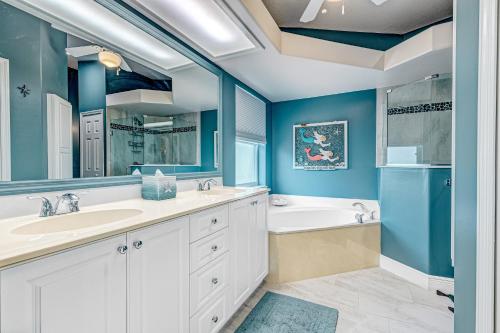 La salle de bains est pourvue de murs bleus, d'une baignoire et d'un lavabo. dans l'établissement R-Time, à Sebastian