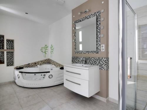 La salle de bains est pourvue d'une baignoire blanche et d'un miroir. dans l'établissement Appartement T4, 2 sdb, 8 pers, Jardin, Local ski, Centre Cauterets - FR-1-401-157, à Cauterets