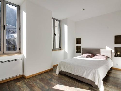 1 dormitorio blanco con 1 cama y 2 ventanas en Appartement Cauterets, 5 pièces, 8 personnes - FR-1-401-157 en Cauterets