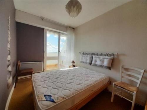 une chambre avec un lit, une chaise et une fenêtre dans l'établissement Appartement Plage Direct, 1 Chambre, 4 Couchages, Non-Fumeur - FR-1-324A-23, à Saint-Hilaire-de-Riez
