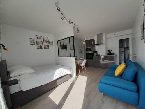 une chambre avec un lit et un canapé bleu dans l'établissement Charmant studio moderne proche plage avec parking privatif à Saint-Hilaire-de-Riez - FR-1-324A-28, à Saint-Hilaire-de-Riez