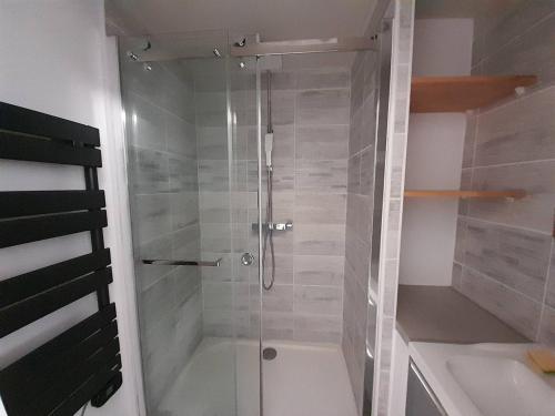 une douche avec une porte vitrée dans une salle de bain dans l'établissement Charmant studio moderne proche plage avec parking privatif à Saint-Hilaire-de-Riez - FR-1-324A-28, à Saint-Hilaire-de-Riez