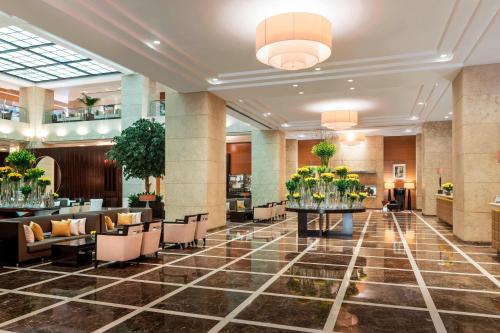 a lobby of a hotel with tables and chairs at Grosvenor House, a Luxury Collection Hotel, Dubai in Dubai