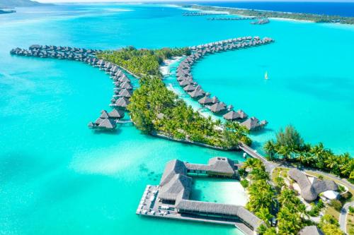 an island in the ocean with overwater bungalows at The St. Regis Bora Bora Resort in Bora Bora