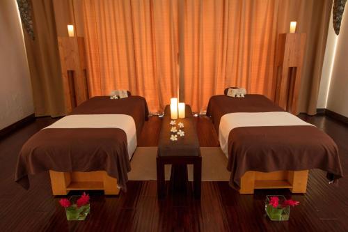 two beds in a room with flowers on a table at The St. Regis Bora Bora Resort in Bora Bora