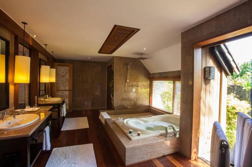 a large bathroom with a tub and two sinks at The St. Regis Bora Bora Resort in Bora Bora