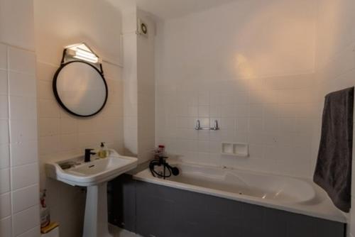 ein Badezimmer mit einem Waschbecken, einer Badewanne und einem Spiegel in der Unterkunft appartement avec vue mer exceptionnelle in Ajaccio