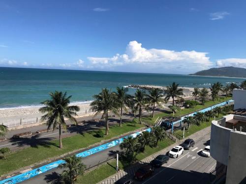 a view of a beach with palm trees and a road at 花蓮諾丁漢海景民宿 Nottingham Seaview Inn in Hualien City