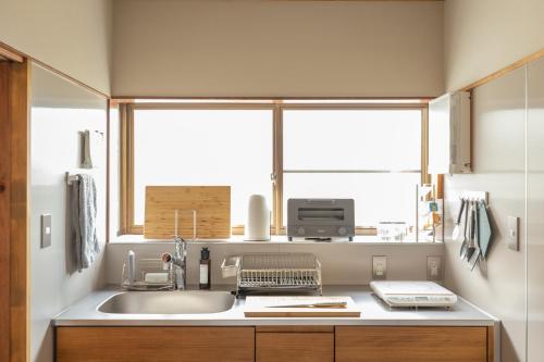 a kitchen with a sink and a window at TEMPLESTAY ZENSŌ in Chiyodamachi