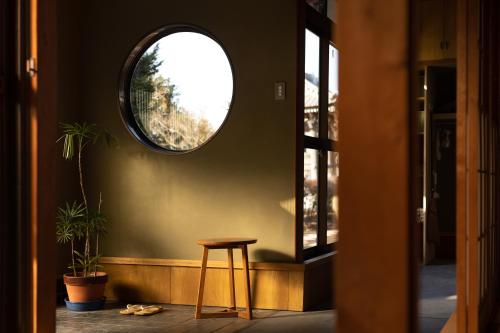 a stool in a hallway with a round mirror at TEMPLESTAY ZENSŌ in Chiyodamachi