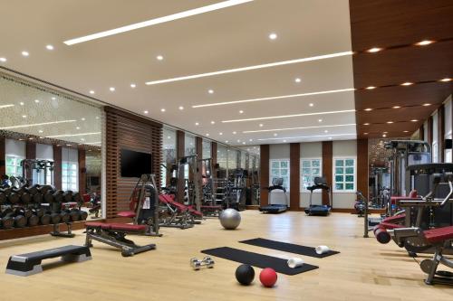 a gym with a lot of treadmills and weights at Al Messila, A Luxury Collection Resort & Spa, Doha in Doha