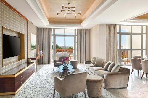 a living room with a couch and a tv at Al Messila, A Luxury Collection Resort & Spa, Doha in Doha