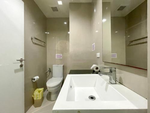 a bathroom with a sink and a toilet and a mirror at The Deck Condo Studios Patong w/ pool fitness in Patong Beach