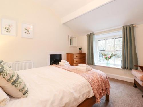 a bedroom with a large bed and a window at Irt Cottage in Seascale