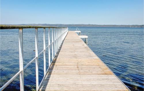 a wooden dock with a bench sitting on top of the water at 3 Bedroom Cozy Apartment In Ebeltoft in Ebeltoft